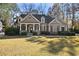 Two-story house with stone accents, large front porch, and landscaped lawn at 403 Pebblebrooke Ln, Canton, GA 30115