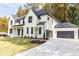 Two-story white brick home with black roof, attached garage, and landscaped lawn at 6175 River Shore Pkwy, Atlanta, GA 30328
