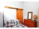 Bright bedroom with a wooden barn door and dresser at 1625 Brushy Mountain Rd, Rockmart, GA 30153
