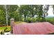Red metal roof of cabin viewed from above, with surrounding trees at 1625 Brushy Mountain Rd, Rockmart, GA 30153
