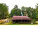 Rustic cabin with metal roof, screened porch, and flagpole, nestled in a wooded setting at 1625 Brushy Mountain Rd, Rockmart, GA 30153