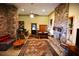 Living room with stone fireplace, ceiling fan, and access to outdoor patio at 1625 Brushy Mountain Rd, Rockmart, GA 30153