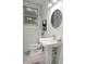 Clean and modern half bathroom with a pedestal sink and a round mirror at 58 Peachtree Memorial Nw Dr # 1, Atlanta, GA 30309
