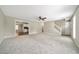Open living room with neutral carpeting, stairs, and kitchen view at 1870 Rocksram Dr, Buford, GA 30519
