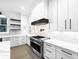 Modern white kitchen with stainless steel appliances and marble countertops at 321 Roper Rd, Canton, GA 30115