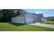 One-story home with gray siding, white garage door, and landscaping at 8590 Seabiscuit Rd, Lithonia, GA 30058