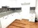 White kitchen with granite countertops, stainless steel appliances, and wood-look flooring at 221 Larkshyre Trl, Lawrenceville, GA 30043