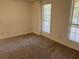 Spacious bedroom with neutral walls, carpet, and two windows at 221 Larkshyre Trl, Lawrenceville, GA 30043