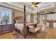 Luxurious main bedroom with hardwood floors, a large four poster bed, and access to the bathroom at 2145 Jones Phillips Rd, Dacula, GA 30019