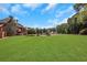 Large grassy backyard with a view of the home and surrounding trees at 2145 Jones Phillips Rd, Dacula, GA 30019