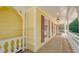 Long side porch with yellow siding and red shutters at 3060 Orchard Sw Rd, Conyers, GA 30094