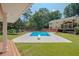 Inviting backyard oasis featuring a sparkling pool, expansive deck, and mature trees at 3060 Orchard Sw Rd, Conyers, GA 30094