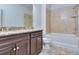 Bathroom with granite countertop, dark vanity, and a tub/shower combo at 6202 Ripple Way # 88, South Fulton, GA 30349