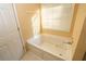 Bathroom with a large jacuzzi tub and neutral color palette at 994 Rolling Forest Ln, Lilburn, GA 30047