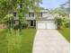 Two-story house with stone and gray siding, two-car garage, and landscaped yard at 1014 Brockdell Ct, Norcross, GA 30093