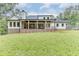 White house back with large covered porch, brick accents, and spacious lawn at 7620 Breeze Bay Rd, Cumming, GA 30041