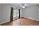 Well lit bedroom with hardwood floors and large window at 220 Fox Hunter Dr, Alpharetta, GA 30022