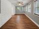 Sunroom features hardwood floors, white brick wall, and multiple windows at 5720 Deerfield Trl, Atlanta, GA 30349