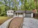 Front view of a charming ranch home with gray garage door at 5720 Deerfield Trl, Atlanta, GA 30349