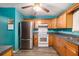 Kitchen with teal walls, wood cabinets, and stainless steel appliances at 315 Watts Rd, Hiram, GA 30141