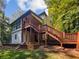 House's back features a deck and stairs leading down to the yard at 709 Tribal Trl, Woodstock, GA 30188