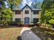 Two-story house with white brick exterior, gray shutters, and a landscaped yard at 709 Tribal Trl, Woodstock, GA 30188