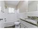 Clean bathroom with white tiled walls, granite vanity, and bathtub at 1278 Lynwyn Se Ln, Atlanta, GA 30316