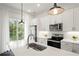 Modern kitchen with white cabinets, stainless steel appliances and island at 201 Devore Rd, Alpharetta, GA 30009