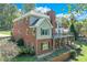 Brick and siding two-story home with a large deck and landscaping at 7280 Timber Trl, Cumming, GA 30041