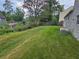 Overgrown backyard with grassy area and a small patio at 1378 Mill Lake Cir, Stone Mountain, GA 30088