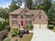 Front exterior of a two-story brick house with a red door and attached garage at 4239 Rockpoint Nw Dr, Kennesaw, GA 30152