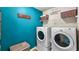 Laundry room with washer, dryer, and teal painted walls at 7619 Sugar Plum Ln, Lithonia, GA 30038