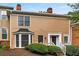 Tan siding townhouse with white trim, landscaping, and steps at 7500 Roswell Rd # 32, Atlanta, GA 30350