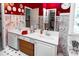 Red and white bathroom with double vanity, large mirror, and decorative wallpaper at 2170 S River Sw Rd, Conyers, GA 30094