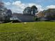 View of the house's back, a large backyard, and a secondary dwelling in the distance at 28 Fawn Ct, Sharpsburg, GA 30277