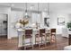 Modern kitchen with island, three barstools, and white cabinetry at 1732 Juniper Berry Way, Loganville, GA 30052