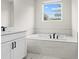 Bathroom with soaking tub and single vanity at 1682 Juniper Berry Way, Loganville, GA 30052