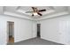 Main bedroom with tray ceiling, ceiling fan, and access to bathroom and other rooms at 80 Stewart Hollow Ln, Covington, GA 30016