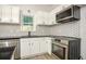 Modern kitchen with white cabinets, stainless steel appliances and hexagon tile at 1614 Abner Nw Ter, Atlanta, GA 30318