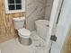 Bathroom with white toilet, bathtub, and marble-look vinyl flooring at 3600 Grady Smith Rd, Loganville, GA 30052