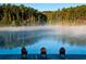 Serene view of a lake with three wooden chairs at 6051 Stallion Rdg, Douglasville, GA 30135