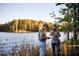 Two men fishing on the peaceful lakefront at 6001 Stallion Rdg, Douglasville, GA 30135