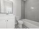 Modern bathroom with gray tile, white vanity, and patterned floor at 4006 Moody Ln, Woodstock, GA 30188