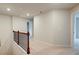 Upstairs hallway with carpet, neutral walls and a metal railing at 311 Tulip Dr, Covington, GA 30016