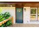 Close-up of the teal front door, white brick exterior, and wood deck at 3152 Spreading Oak Sw Dr, Atlanta, GA 30311