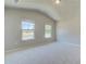 Spacious bedroom with vaulted ceiling, neutral carpeting, and two windows at 201 Haverling Pass, Hampton, GA 30252