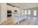 Bright kitchen featuring white cabinets, island, and view to Gathering room at 201 Haverling Pass, Hampton, GA 30252