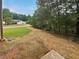Landscaped backyard with mature trees and partial view of street at 9105 Sterling Lakes Cir, Covington, GA 30014