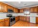 Bright kitchen featuring wood cabinets, stainless steel appliances, and hardwood floors at 497 Freedom Dr, Mcdonough, GA 30252