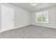 Well-lit bedroom with grey carpet, a window, and a closet at 2146 Silva Ct, Conley, GA 30288